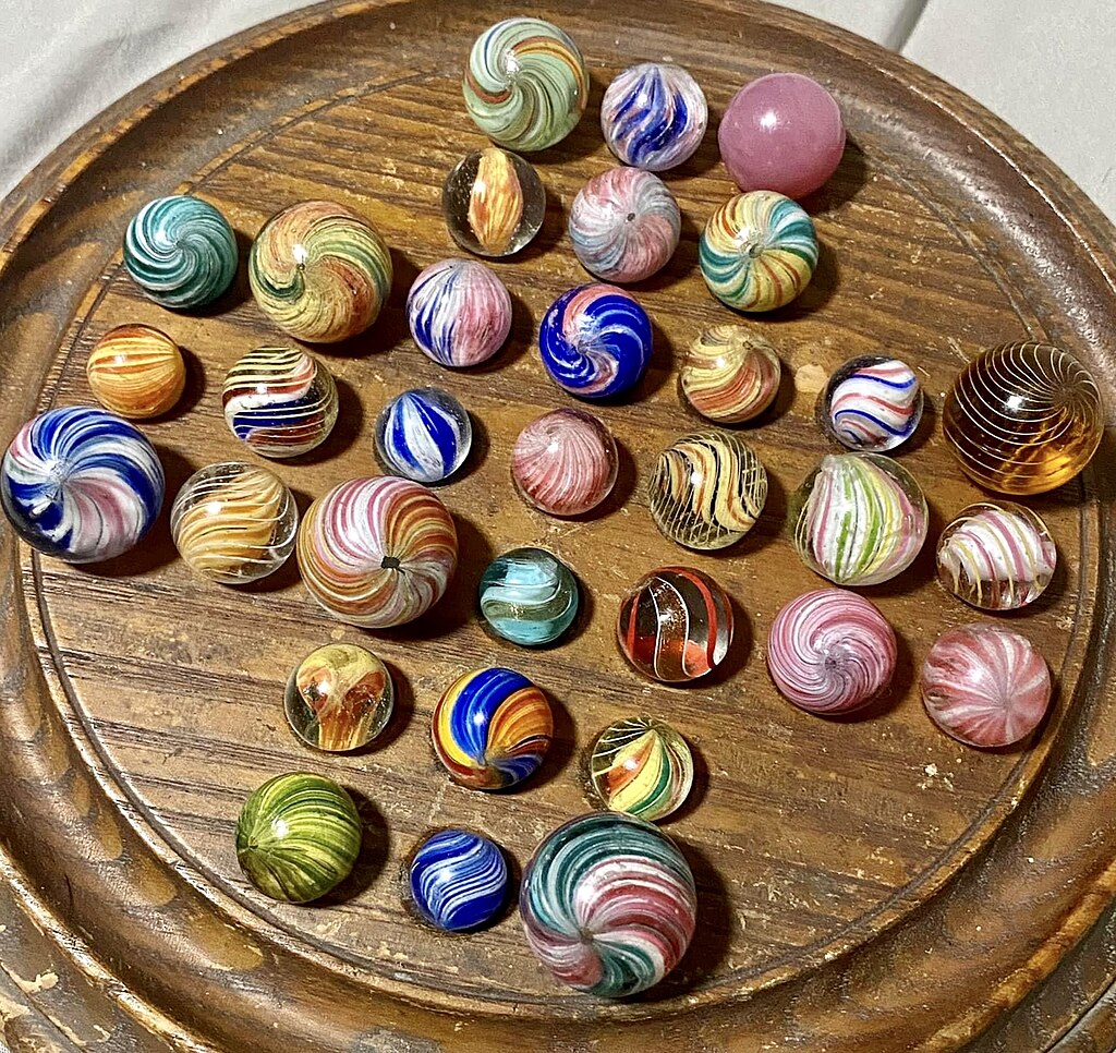 Marbles arranged neatly on a board, illustrating an ordered structure.